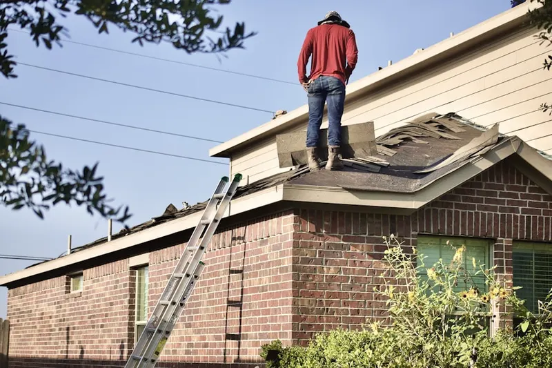 Professional roofer working on a residential roof in Payne
